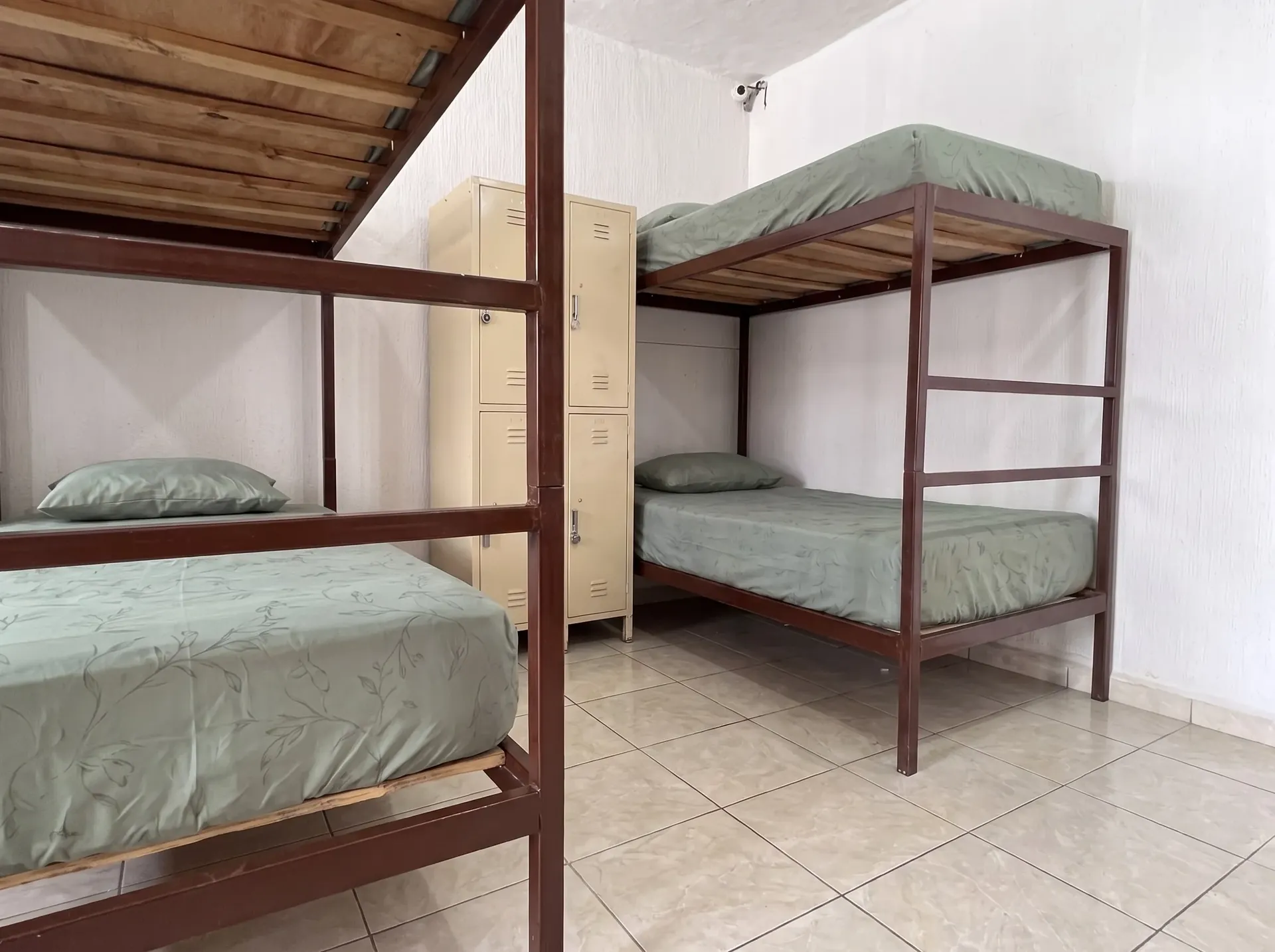 Dormitorio individual ordenado con luz natural para descanso digno en Casa Consuelo.